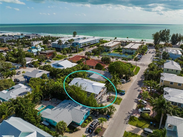 drone / aerial view featuring a beach view and a water view