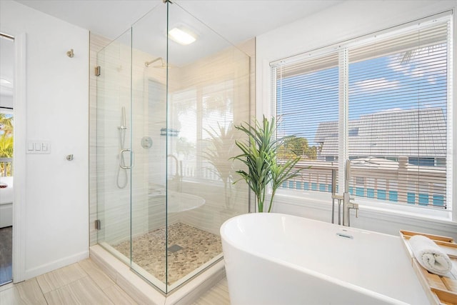 203 72nd St, Holmes Beach, FL 34217 - bathroom with tile patterned floors, a freestanding tub, baseboards, and a stall shower