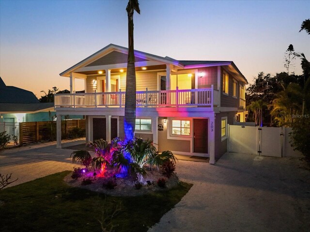 203 72nd St, Holmes Beach, FL 34217 - back of property at dusk featuring fence, a balcony, and a gate