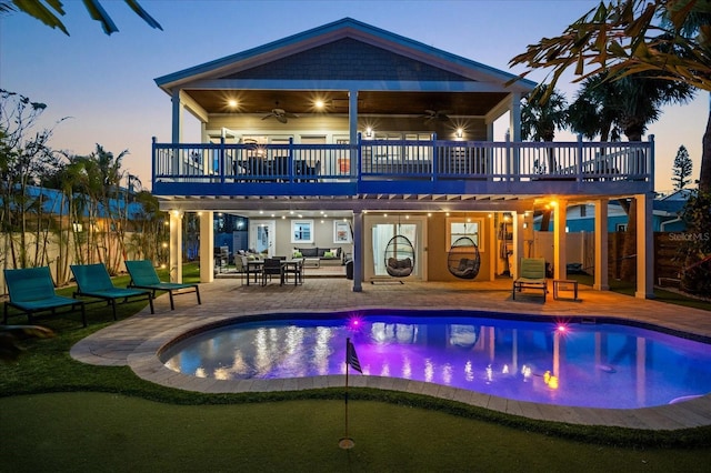 203 72nd St, Holmes Beach, FL 34217 - back of house at dusk featuring a wooden deck, a ceiling fan, a patio area, fence, and a fenced in pool