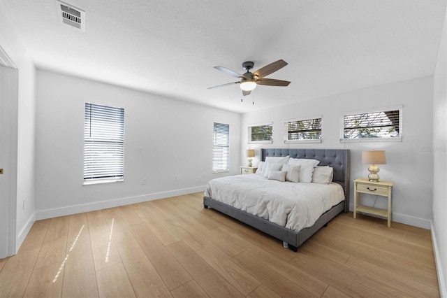 bedroom featuring multiple windows, ceiling fan, and light hardwood / wood-style floors