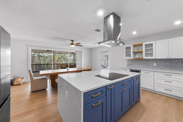 kitchen with white cabinets, blue cabinets, black electric cooktop, a kitchen island, and island exhaust hood