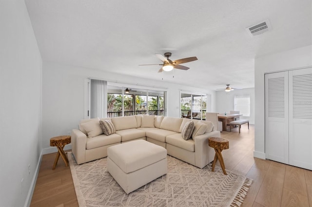 living room featuring ceiling fan and light wood-type flooring