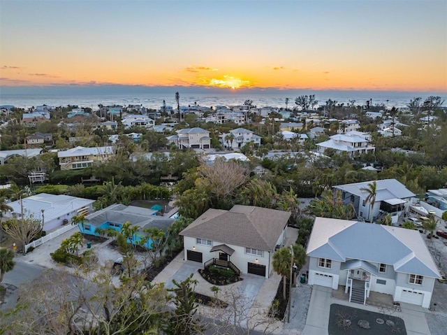 aerial view at dusk featuring a water view