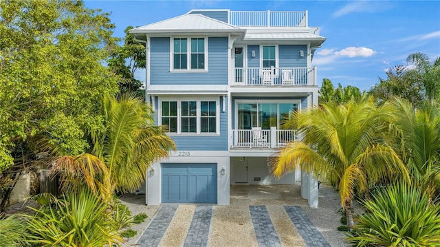 raised beach house with a garage and a balcony