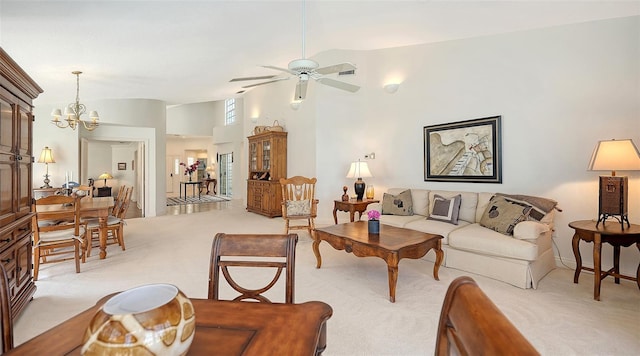 carpeted living room featuring high vaulted ceiling and ceiling fan with notable chandelier