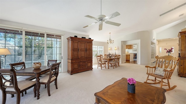 carpeted dining room with lofted ceiling and ceiling fan with notable chandelier