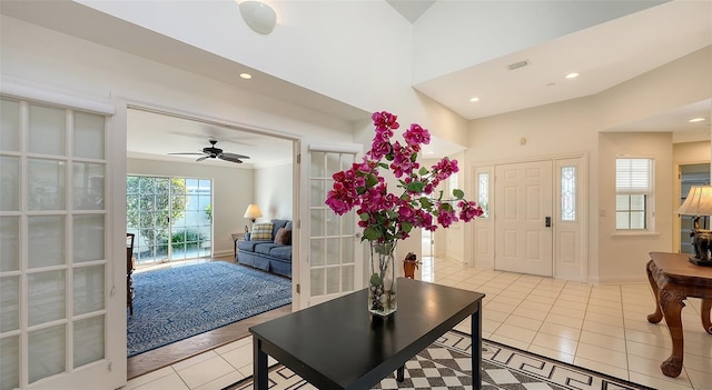 tiled entrance foyer featuring ceiling fan and ornamental molding