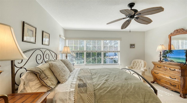 carpeted bedroom with a textured ceiling and ceiling fan