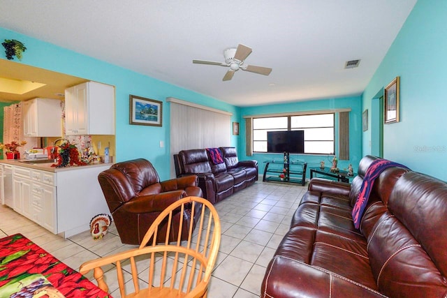 tiled living room with ceiling fan and sink