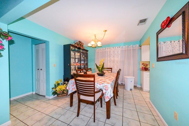 dining space featuring light tile patterned flooring and a notable chandelier