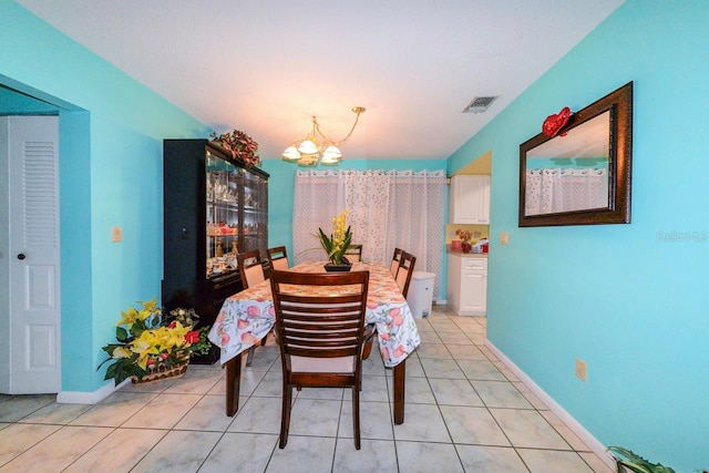 tiled dining space featuring a chandelier