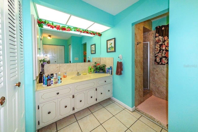 bathroom featuring tiled shower, tile patterned flooring, backsplash, and vanity