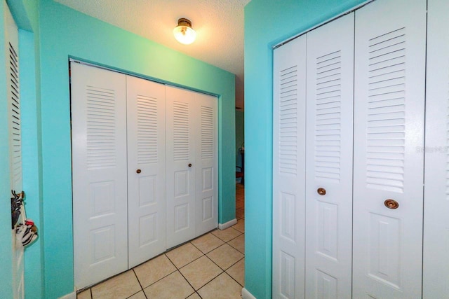 hall with light tile patterned floors