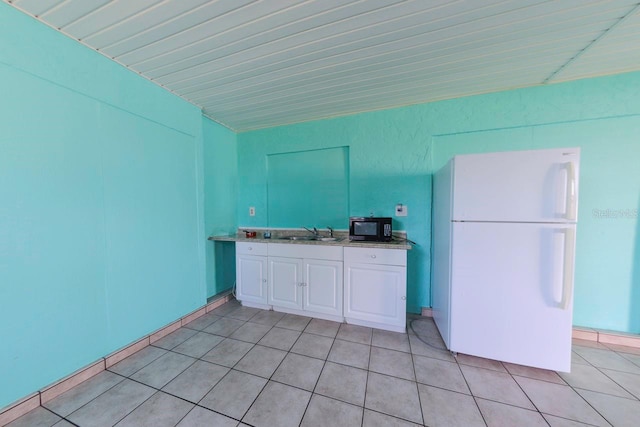 kitchen featuring white refrigerator, white cabinetry, and sink