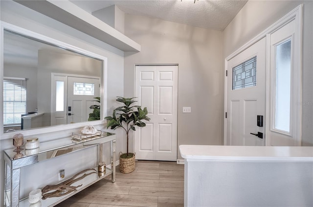 foyer entrance featuring light wood-type flooring and a textured ceiling