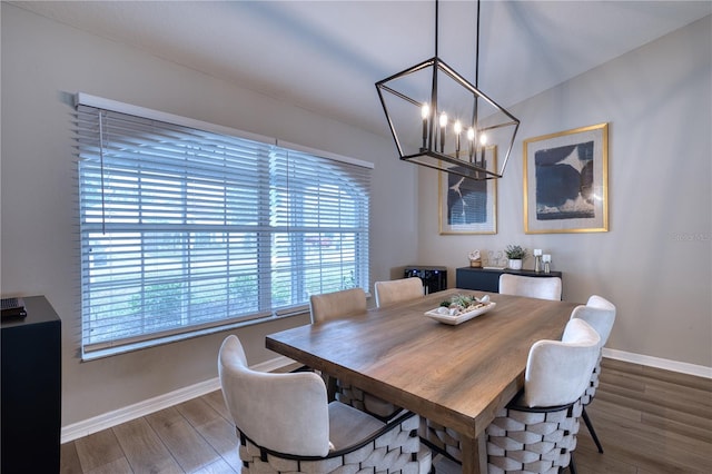 dining area featuring wood-type flooring and a notable chandelier