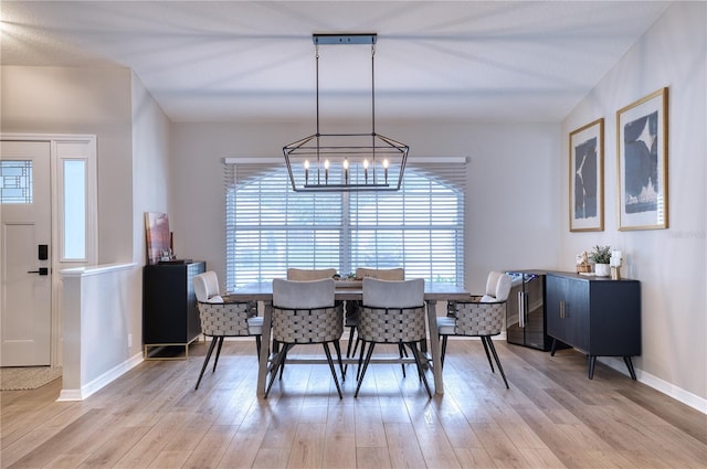 dining area featuring light hardwood / wood-style flooring and an inviting chandelier