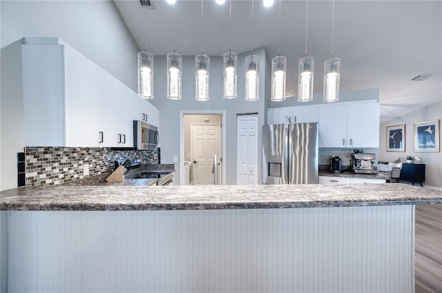 kitchen featuring hanging light fixtures, white cabinets, kitchen peninsula, and appliances with stainless steel finishes