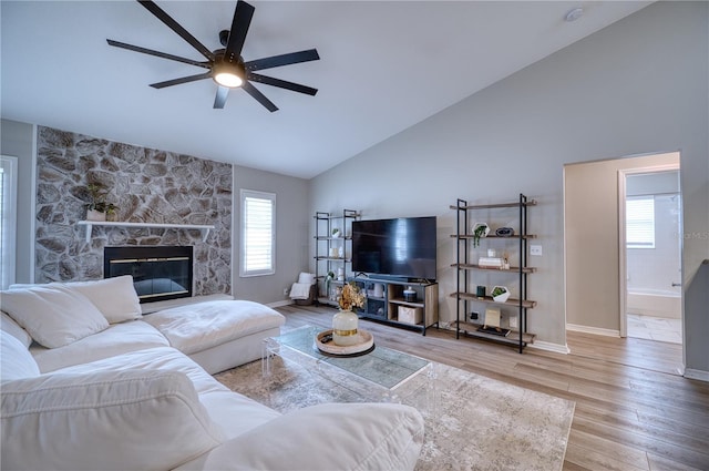 living room with hardwood / wood-style flooring, a wealth of natural light, ceiling fan, and a fireplace