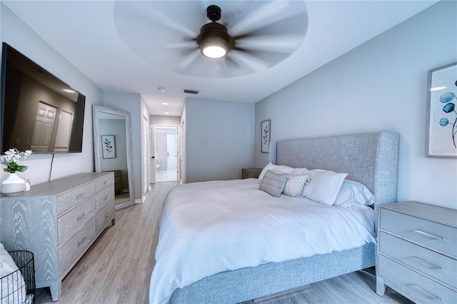 bedroom featuring ceiling fan, connected bathroom, and light wood-type flooring