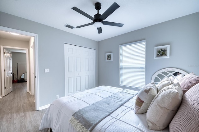 bedroom featuring light wood-type flooring, a closet, and ceiling fan