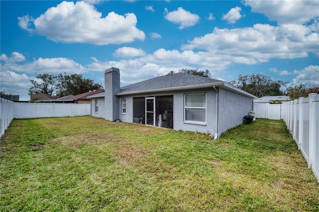 back of property with a yard and a sunroom