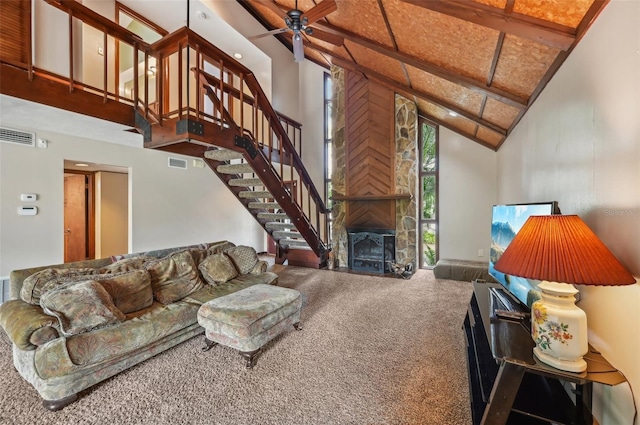 living room with high vaulted ceiling, ceiling fan, a stone fireplace, and carpet flooring