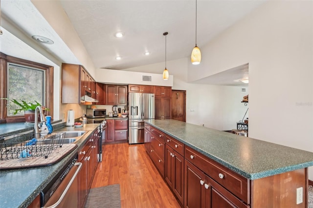 kitchen with a center island, lofted ceiling, stainless steel appliances, sink, and light wood-type flooring