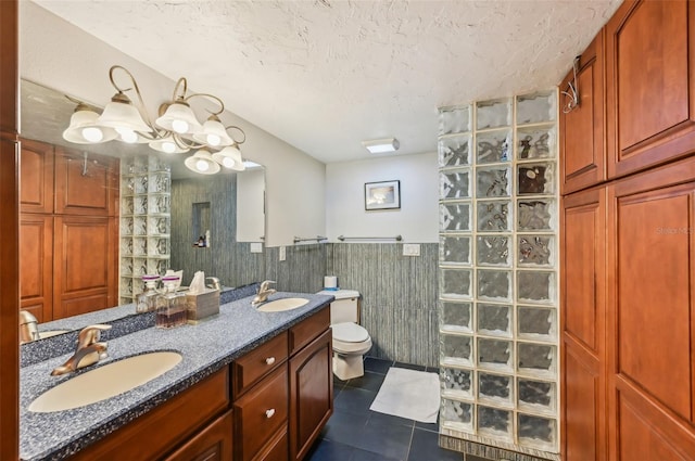 bathroom featuring toilet, tile patterned floors, walk in shower, a textured ceiling, and vanity