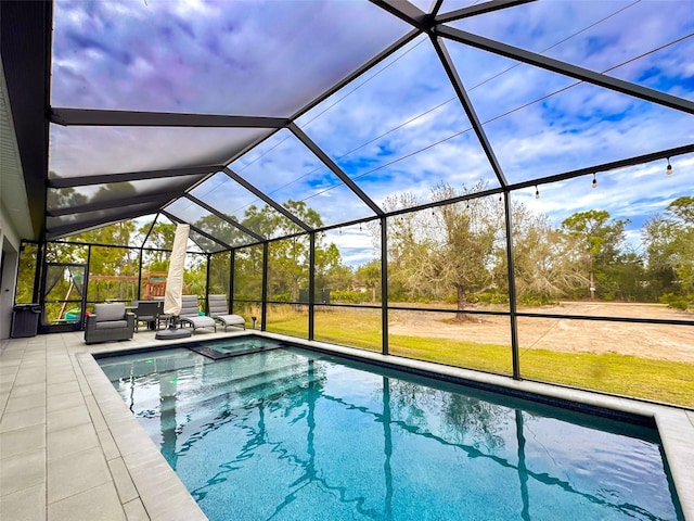 view of swimming pool with a lanai, outdoor lounge area, and a patio