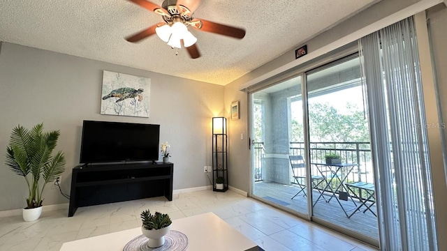 living room featuring ceiling fan and a textured ceiling