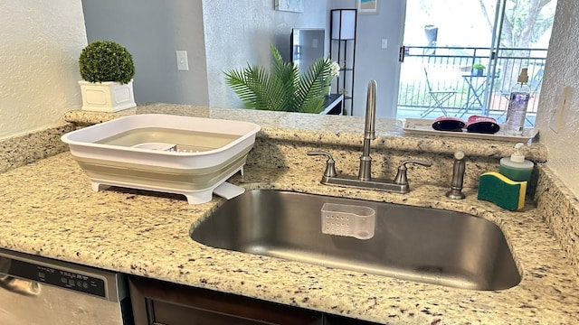 room details with dishwasher, light stone counters, and sink