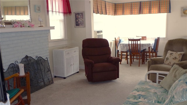 living room with carpet floors, a brick fireplace, and radiator