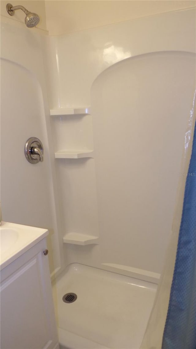 bathroom featuring vanity and curtained shower