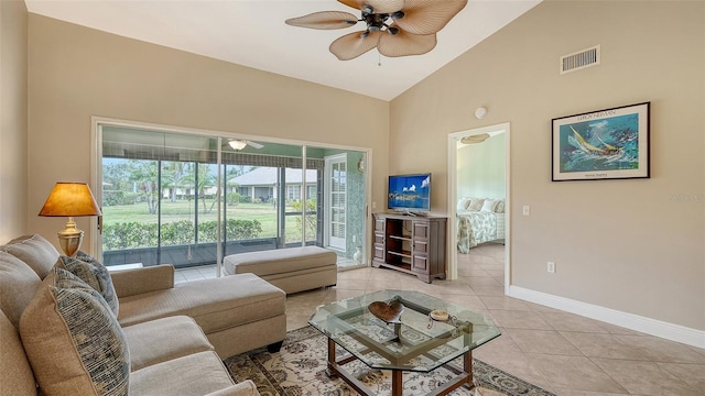 tiled living room with ceiling fan and high vaulted ceiling