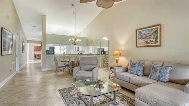 tiled living room featuring high vaulted ceiling and ceiling fan with notable chandelier