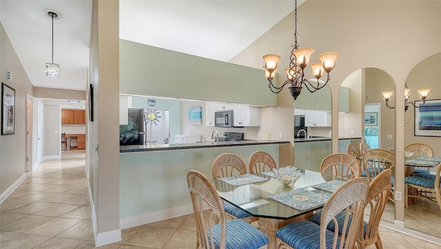 dining space featuring light tile patterned floors, sink, high vaulted ceiling, and a notable chandelier