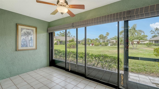 unfurnished sunroom with ceiling fan