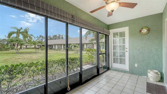 unfurnished sunroom with ceiling fan