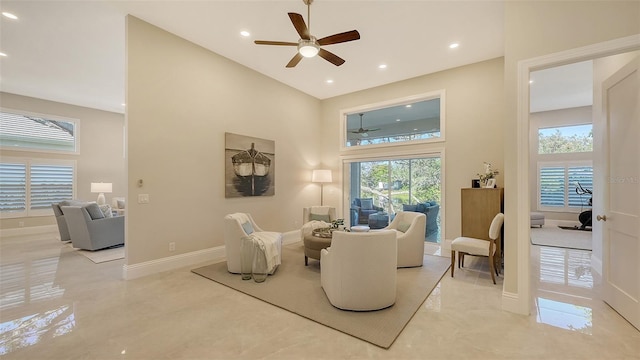 living room featuring ceiling fan and a towering ceiling