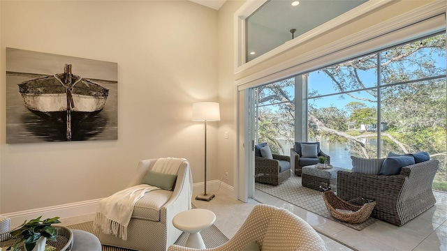 sitting room featuring light tile patterned floors and a water view