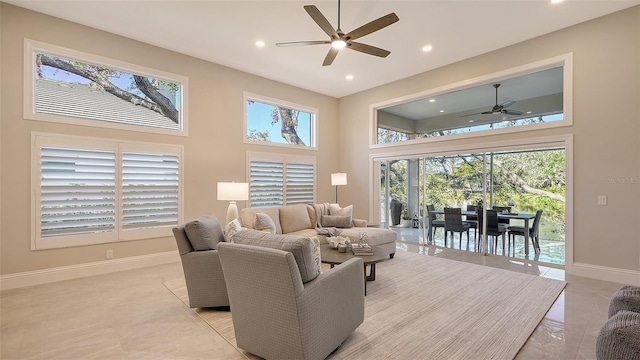 living room with ceiling fan and a high ceiling