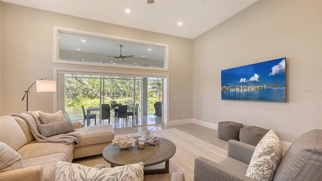 living room with ceiling fan and a towering ceiling