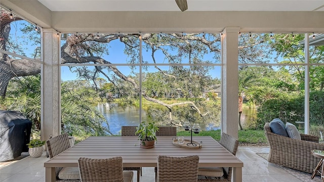 sunroom featuring a water view