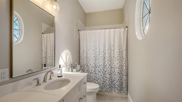 bathroom with toilet, vanity, and tile patterned floors