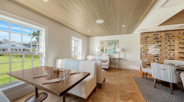 dining space with wood ceiling and light parquet floors