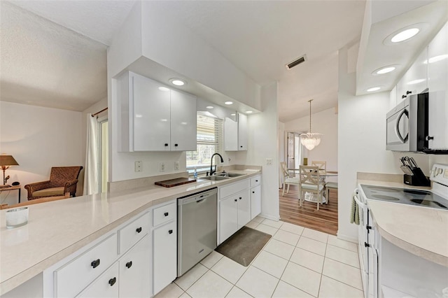 kitchen featuring white cabinetry, sink, decorative light fixtures, light tile patterned flooring, and appliances with stainless steel finishes