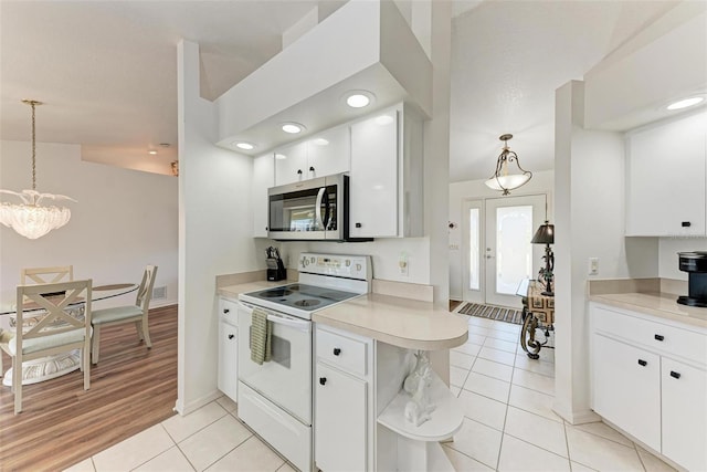 kitchen featuring pendant lighting, light tile patterned flooring, white cabinetry, and white electric stove