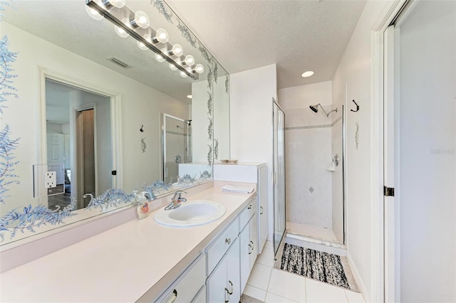 bathroom with tile patterned flooring, an enclosed shower, and a textured ceiling